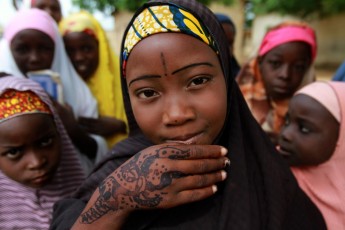 A girl displays traditional paintings on her hand in front of a local Koranic school on the second day of Ramadan in Nigeria’s northern city of Kano, on July 21, 2012.